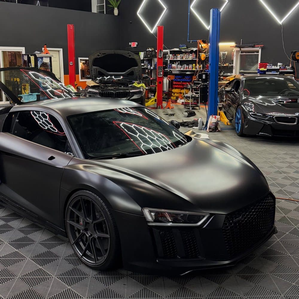 A matte Audi R8 under the hex lights in the Toros Customs shop