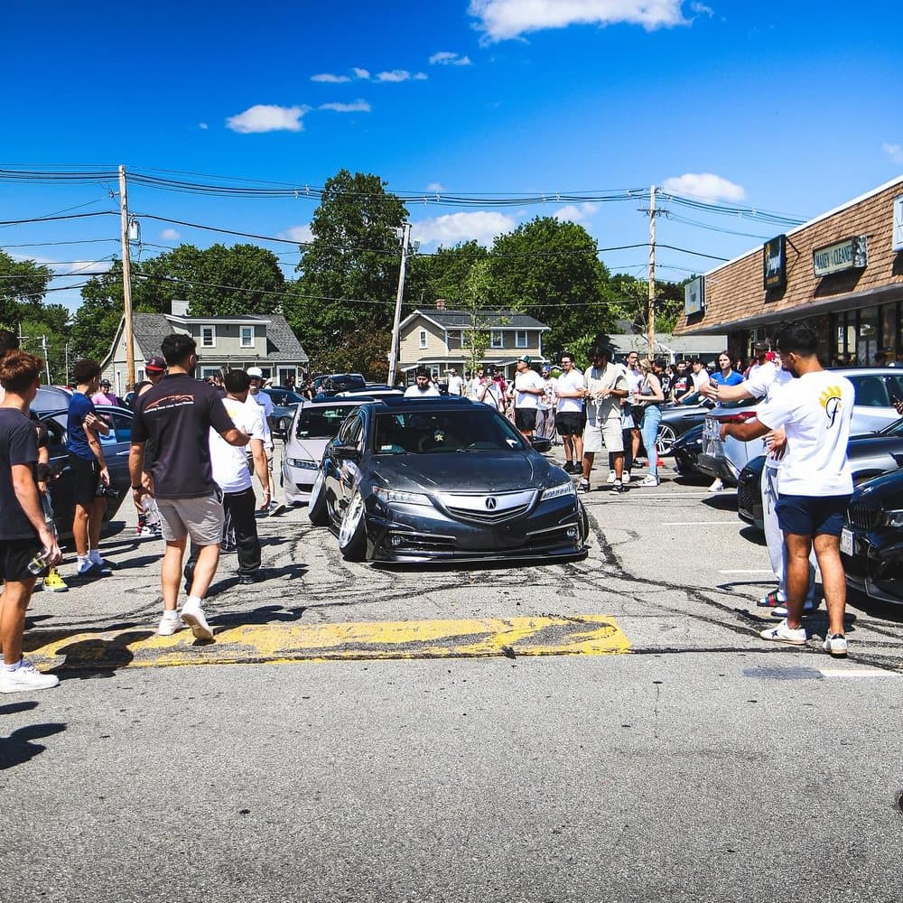 A crowd and cars at an outdoor car meet